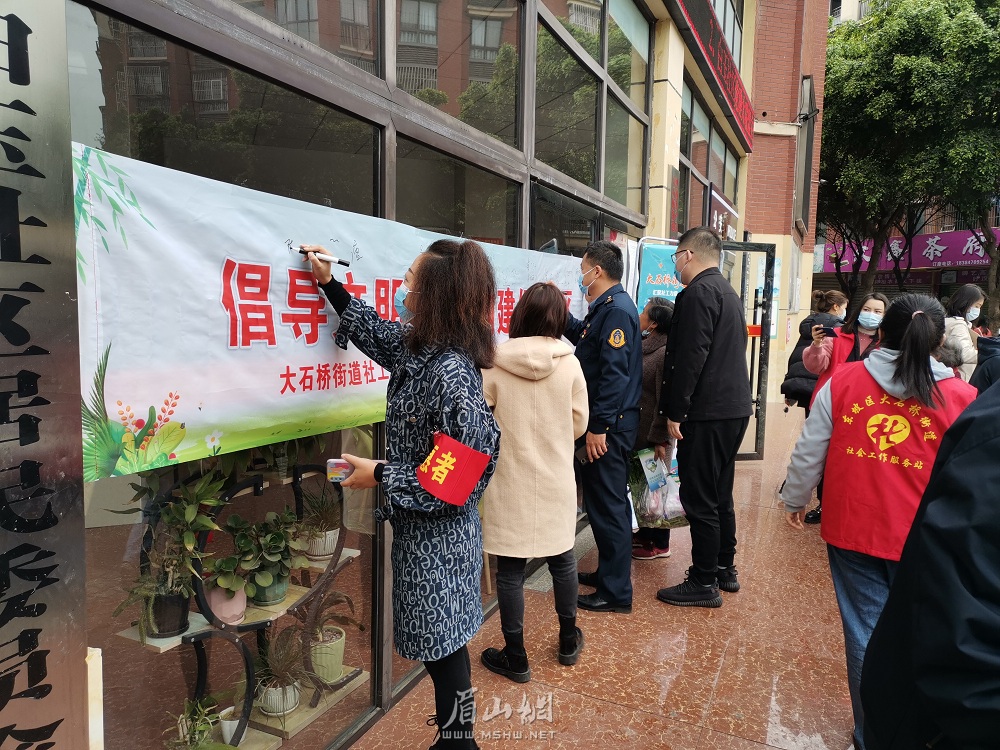 在文明新風倡導簽名墻前，轄區居民和志愿者們鄭重簽名。.jpg