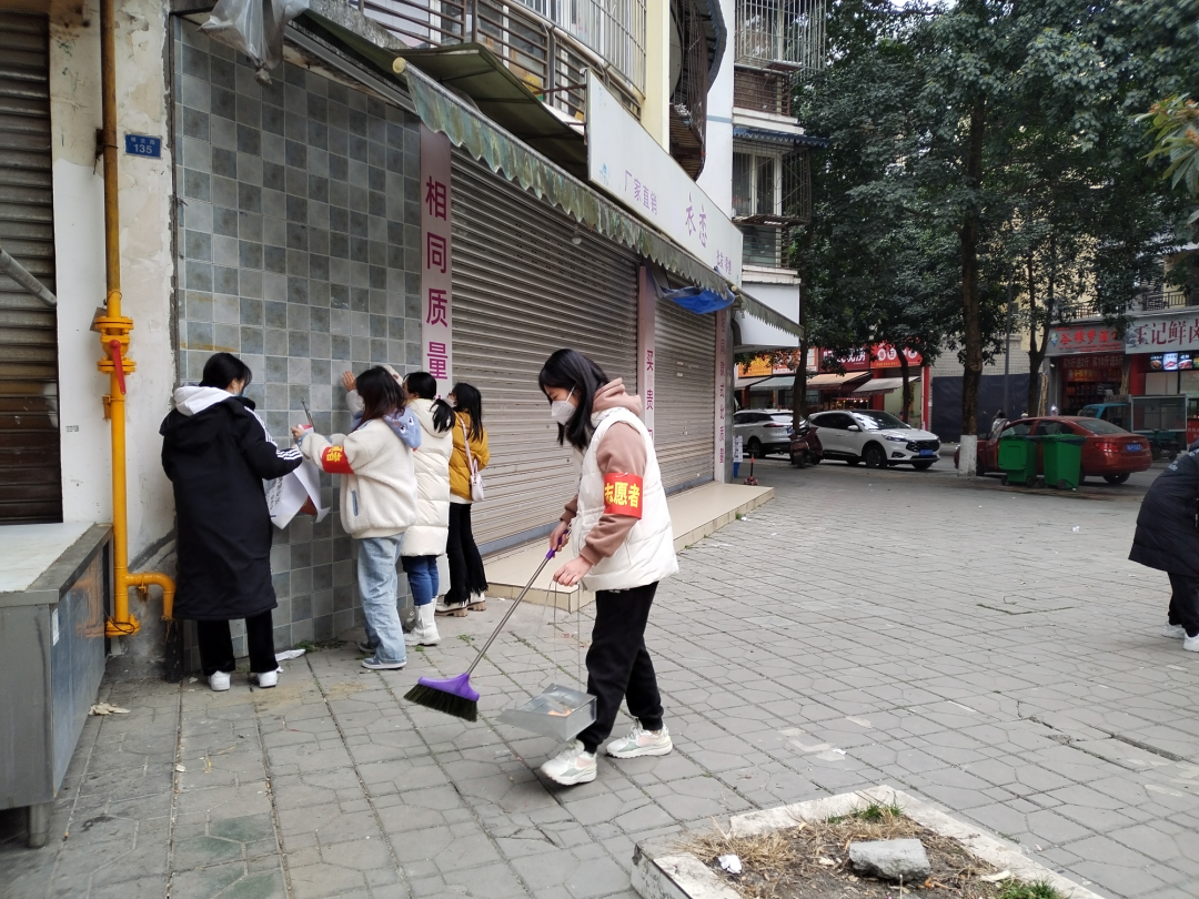 志愿者清理“牛皮癬”和街面垃圾。.jpg