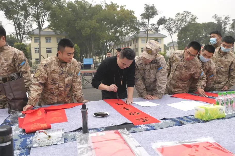 官兵們圍在書法家身邊欣賞書法作品。.jpg
