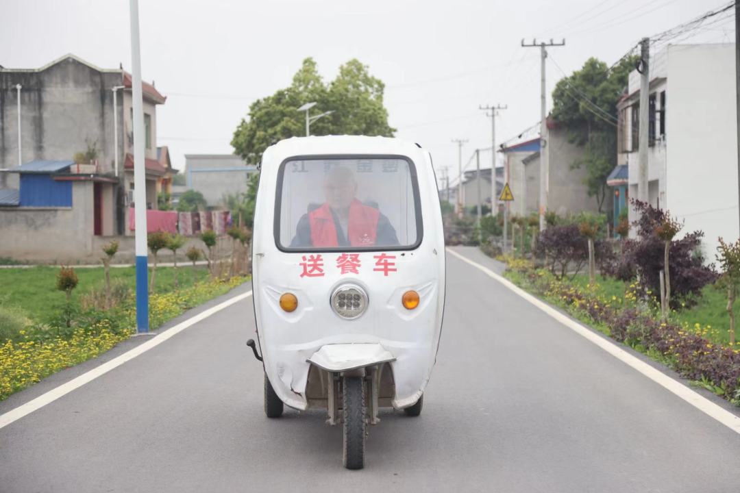 楊永東騎著“送餐車”，行駛在道路上。.jpeg