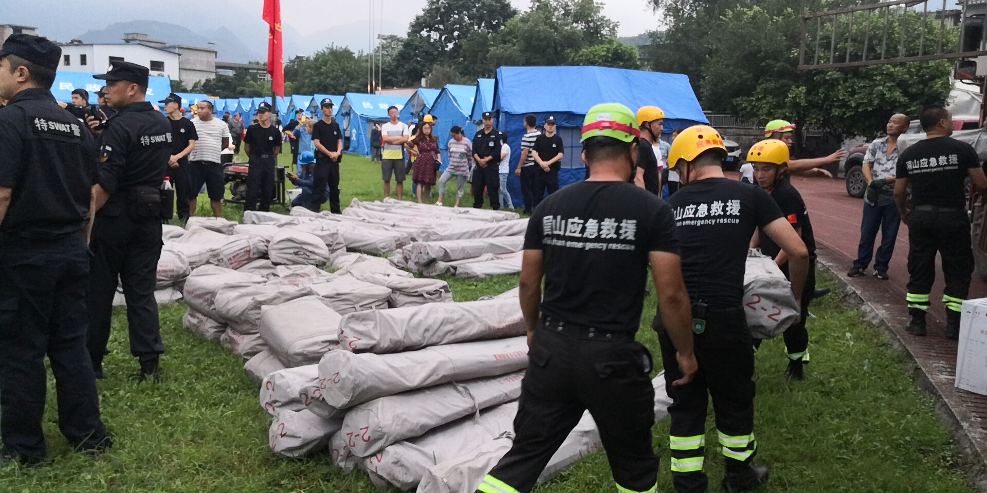 18日晚7時20分左右，救援隊員和武警官兵冒雨為群眾搬運救災帳篷。2.jpg