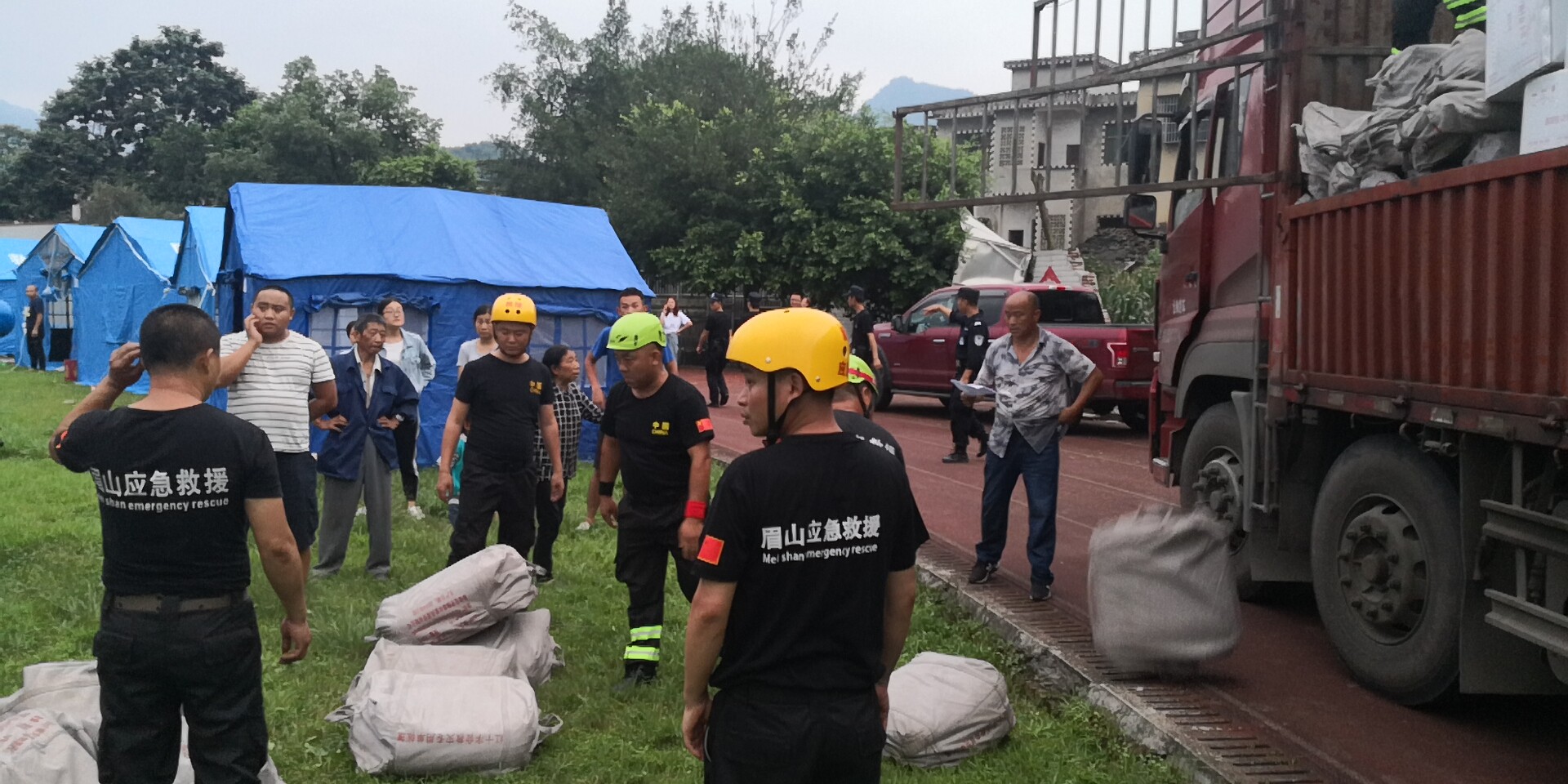 18日晚7時20分左右，救援隊員和武警官兵冒雨為群眾搬運救災帳篷。7.jpg