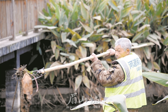 徐雙貴正在打撈河道雜物。.jpg