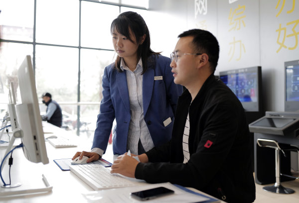 行政審批部門的工作人員現(xiàn)場指導(dǎo)辦事群眾。