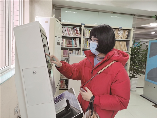 柯景如使用自助借還機自助還書。