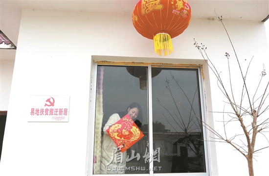 仁壽縣幫扶干部為建檔立卡貧困戶新家貼福字。記者 郭僑 攝