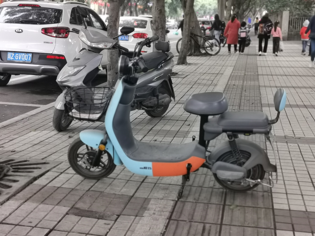 江鄉路人行道上，一輛占用盲道的電瓶車有些突兀。.jpg