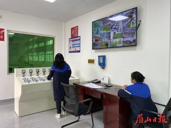 值班室，兩名工作人員相互配合，保障水廠正常運行。