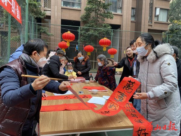 送春聯(lián)進(jìn)小區(qū)，送上新春祝福。