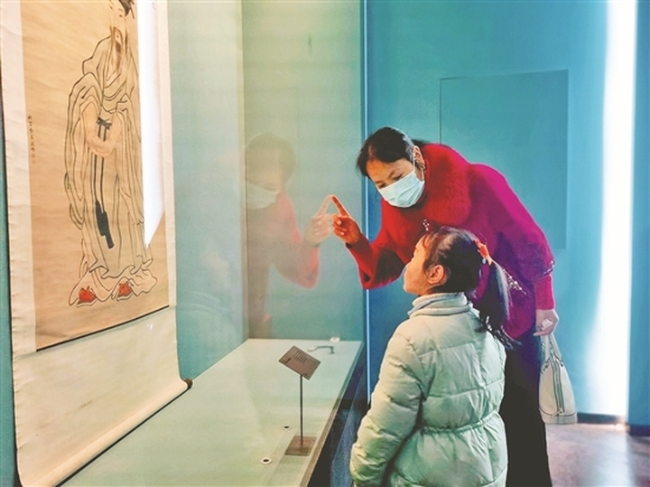 在三蘇祠舉辦的“吾家東坡──蘇軾題材文物特展·《蘇軾書法全集》（四十五冊本）圖錄特展”中，家長和孩子一起觀展。