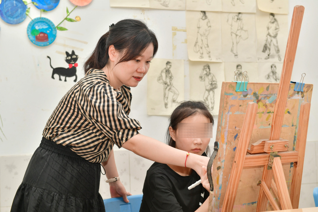 曾真老師正在指導學生畫畫。.jpg