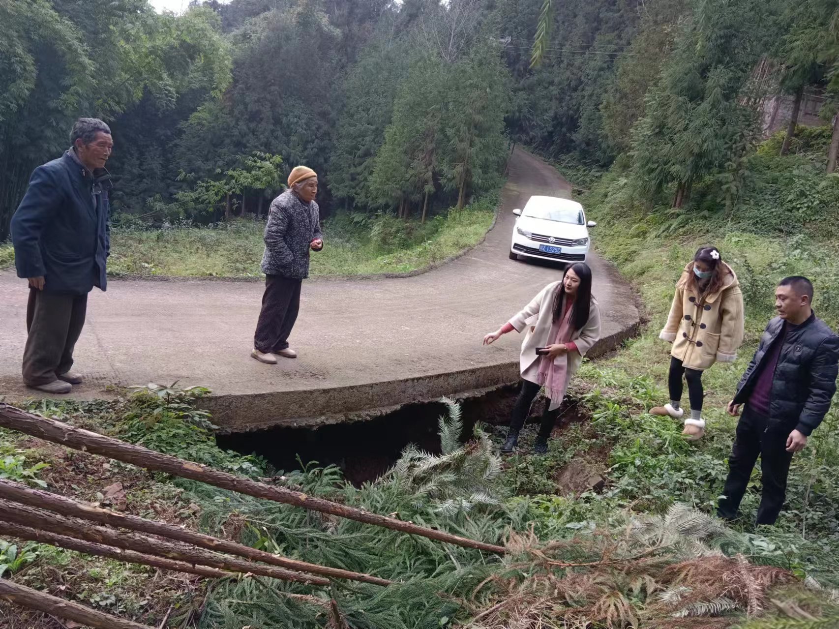 柳江鎮兩河村駐村工作隊勘查堡坎垮塌路面。