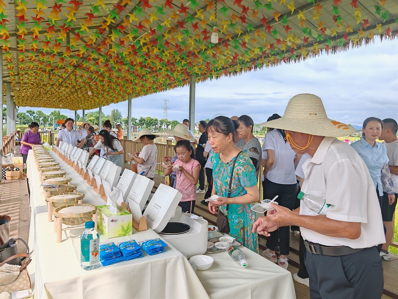  活動現(xiàn)場大米品鑒區(qū)，村民正在品嘗新品種大米。