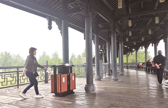 東坡城市濕地公園的望月臺空中廊橋上，市民將垃圾扔進垃圾箱。.jpg