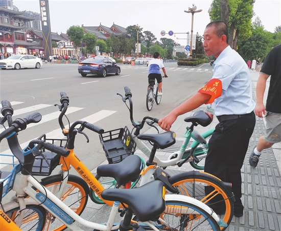 杜曾壯挪動(dòng)亂停放的共享單車(chē)。.jpg